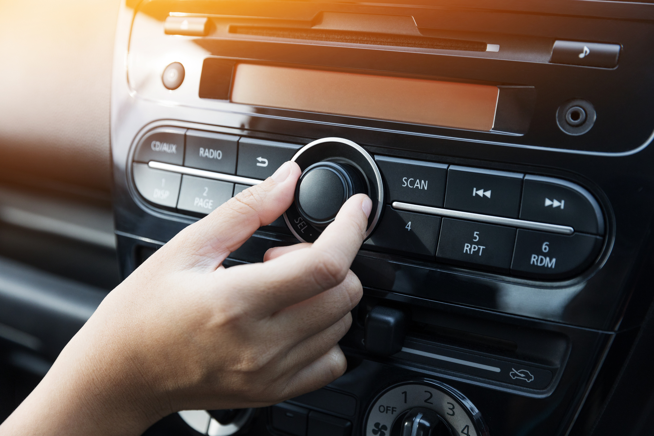 Woman turning button of radio in car Women turning button on car radio for listening to music