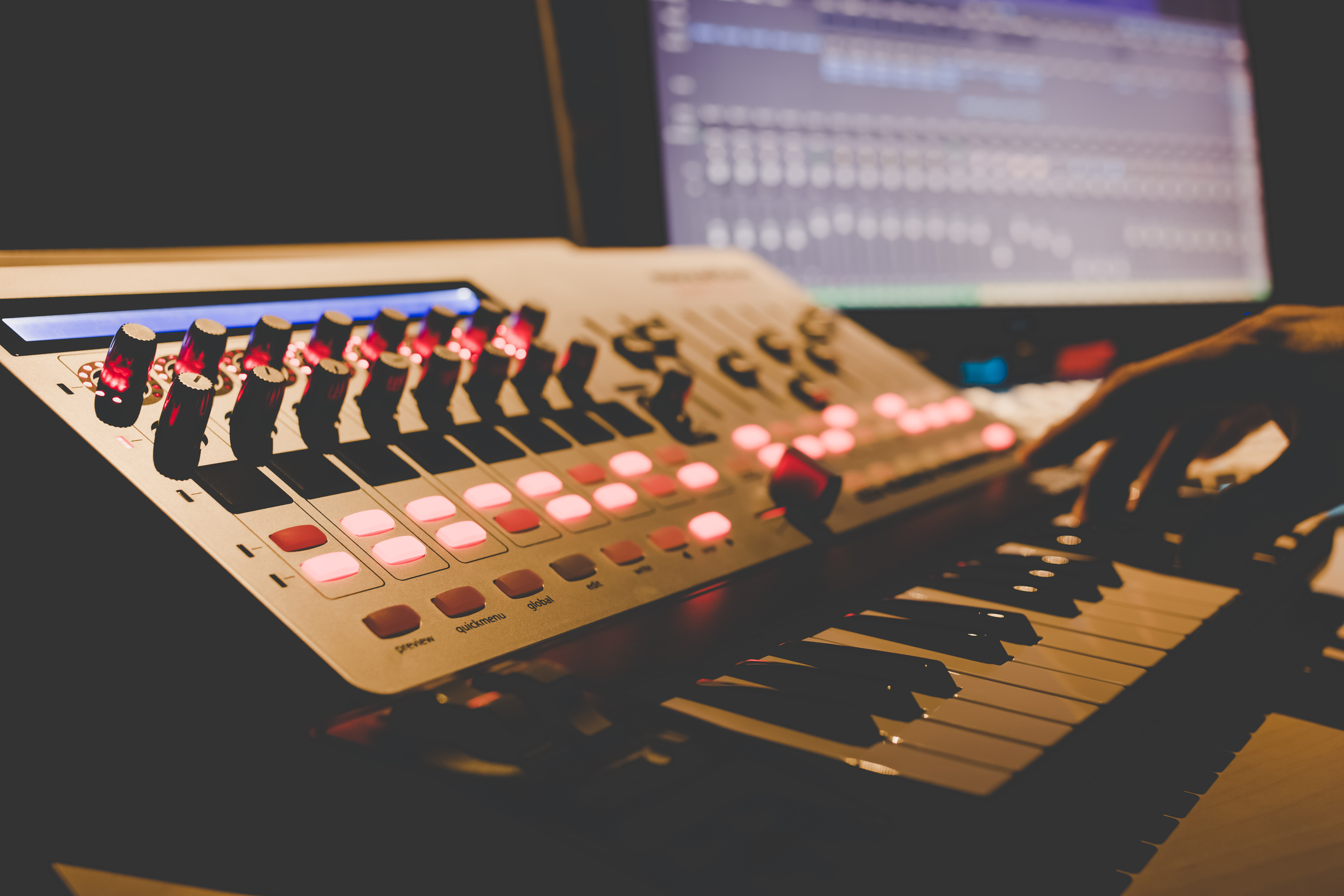 music producer hands playing midi keyboard synthesizer in recording studio, shallow dept of field. focus on knob Bilde fra studio.