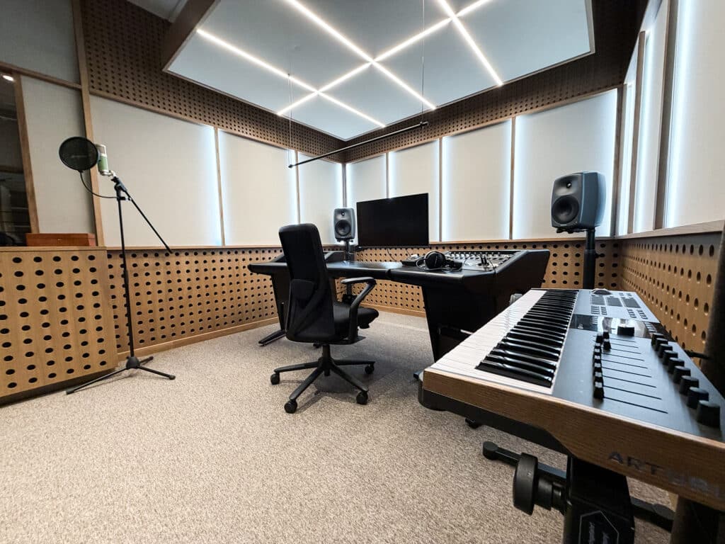 Bilde av profesjonelt studio beregnet på å komponere musikk i for TONOs medlemmer. Lyst rom, et keyboard, en pult, skjerm og høyttalere. 