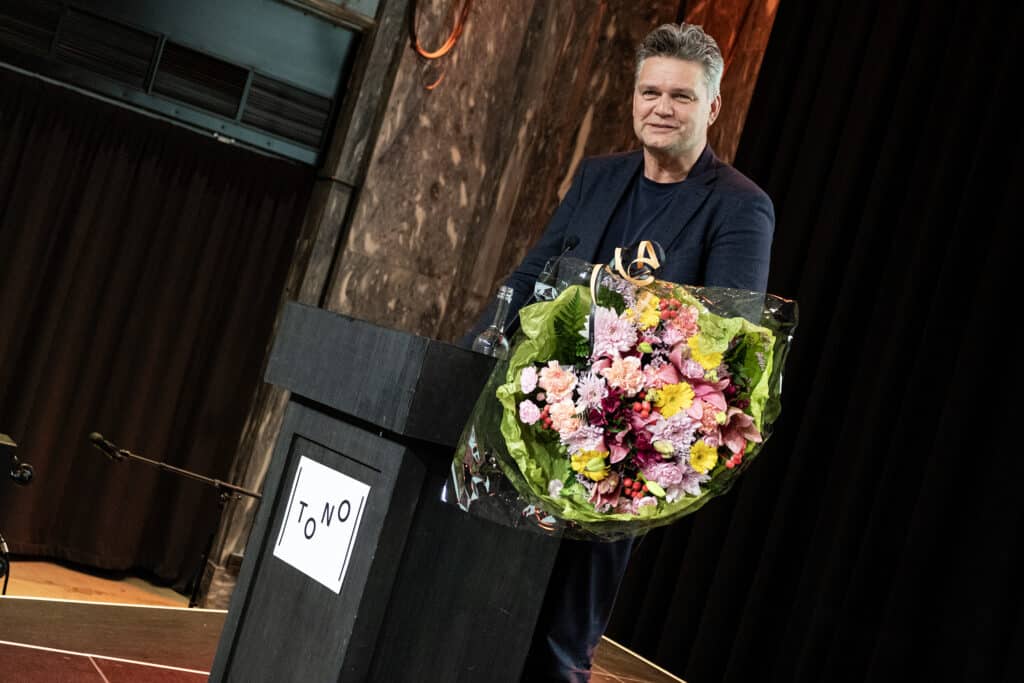 Bilde av avtroppende styreleder i TONO, Ole Henrik Antonsen, med blomster. 
